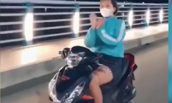 Cô gái chạy xe máy thả 2 tay... múa quạt bị phạt 7,4 triệu đồng